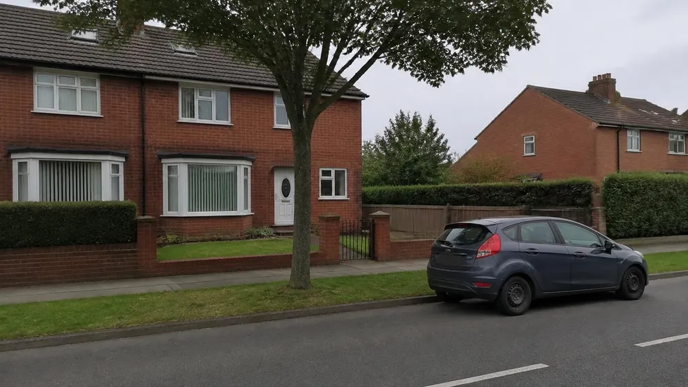 Grass verge and street tree between the road and a house with no driveway