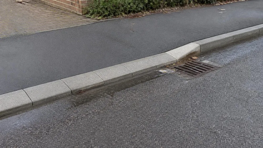 Close-up of lowered kerb stones and a transition kerb at a driveway crossing